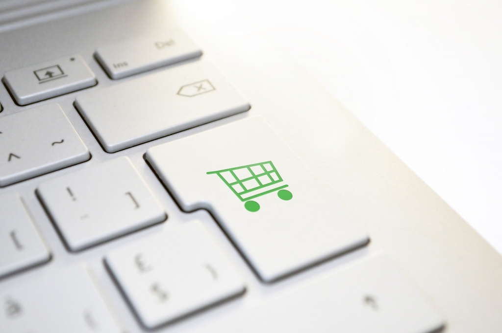 computer keyboard with a shopping cart button in green