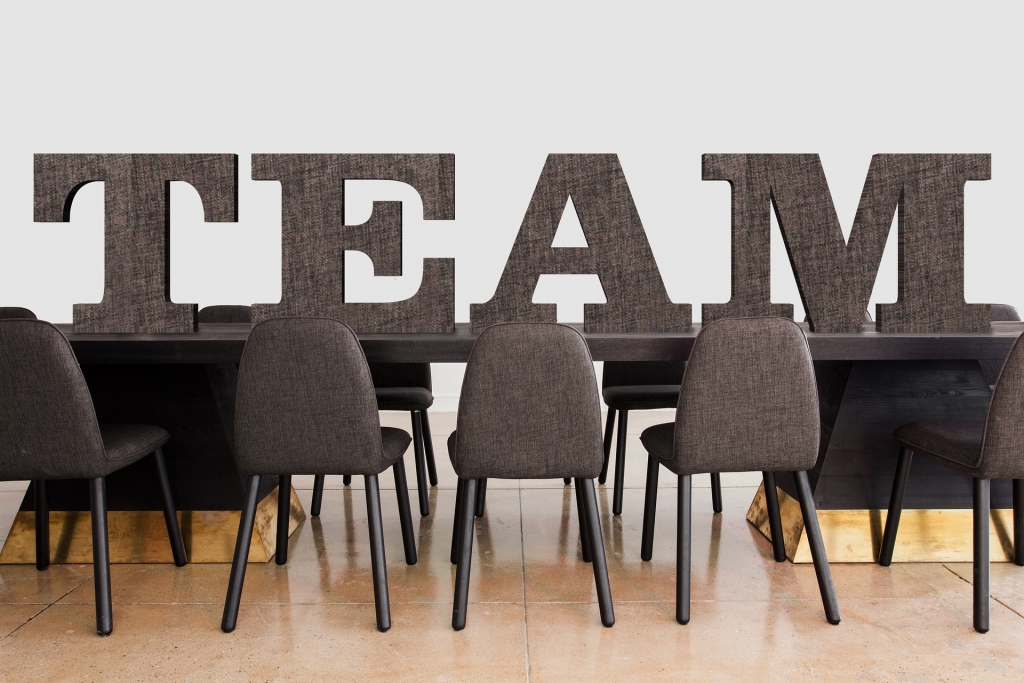 gray table & chairs with the word team above it