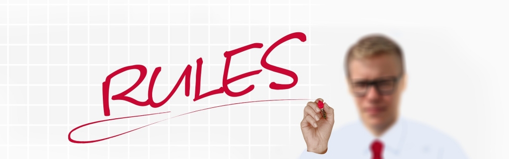 the word rules written in red. Person holding marker in background