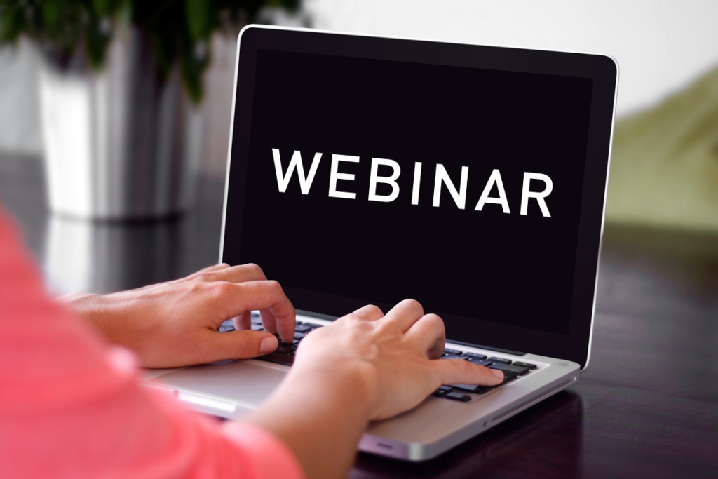 woman typing on laptop with the words Webinar on the screen